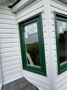 A green window frame from EcoTech adds a fresh, natural touch to the home's exterior, perfect for a summer refresh.