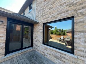 Black sliding patio door leading to a beautiful outdoor oasis, enhancing natural light and ventilation in a modern home during summer.