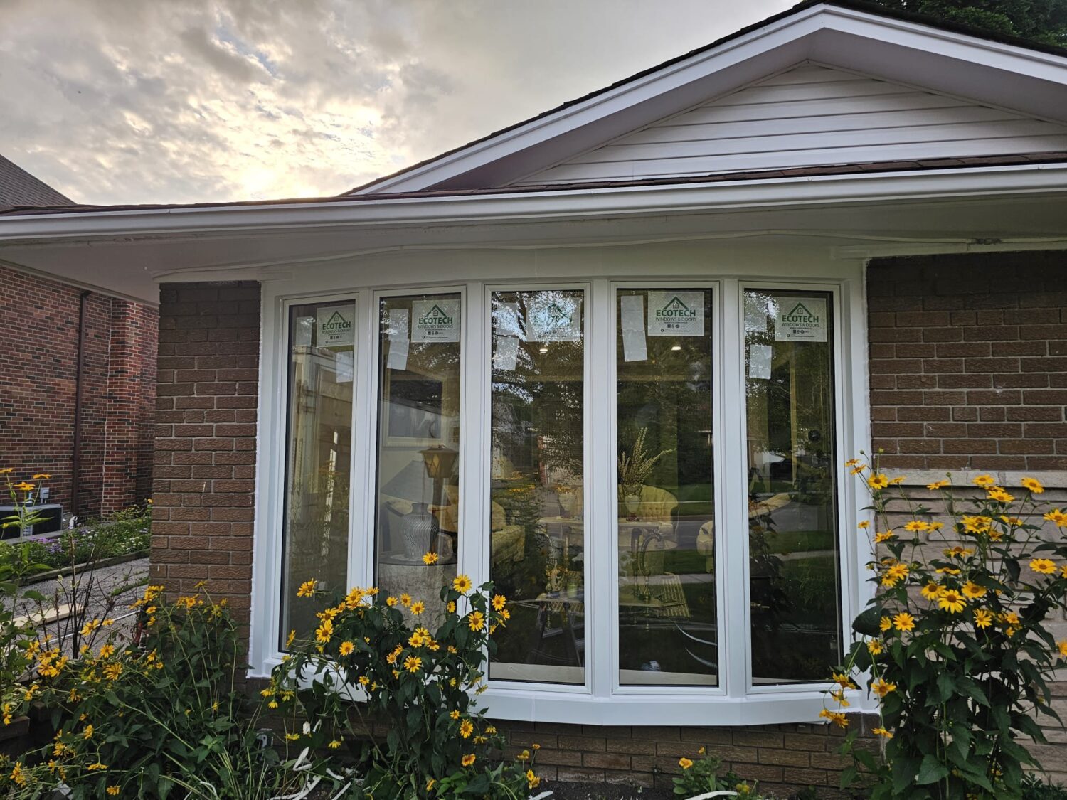 Bow windows installed by EcoTech Windows and Doors, enhancing the exterior of a home with their curved design and multiple glass panels.