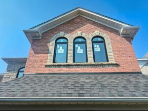 Hung window with an arched top, showcasing a classic design with vertically sliding panes, set in a home's facade.