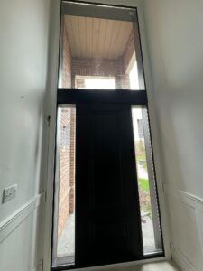 Interior view of a front door with a sidelight, allowing natural light to brighten the room and enhance the entryway