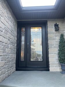 Single panel sidelight next to a sleek black door, featuring a clear glass panel that complements the modern design of the entryway. Showcased by EcoTech Windows and Doors.