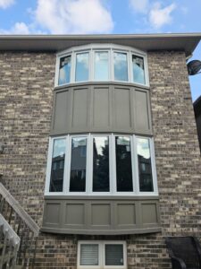 A bow window in a home, featuring a curved arrangement of multiple glass panels that extend outward, creating a panoramic view and adding architectural interest.