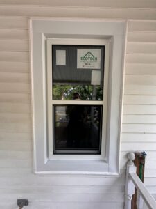 A close-up of hung windows with two sashes, one sliding vertically over the other, allowing for adjustable ventilation in a home.