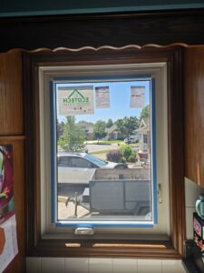 Casement window installation in a Toronto home, showing the window opened outward on its side hinge, highlighting the professional fit and finish.