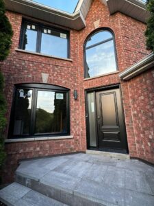 A charming red brick home featuring EcoTech windows and doors, showcasing modern design and energy efficiency in a residential setting.